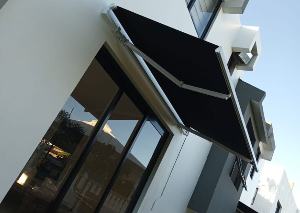 Toldo de tela retráctil manual en una fachada